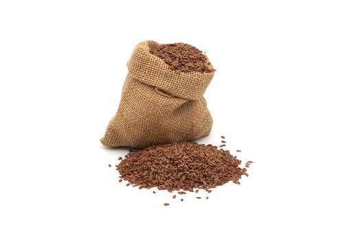 A burlap sack brimming with flax seeds, accompanied by a small pile, all on a white background, ready for use.