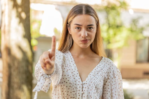 Displeased upset Caucasian woman reacting to unpleasant awful idea, dissatisfied with bad quality, wave hand, shake head No, dismiss idea, dont like proposal. Young adult lady traveler on city street