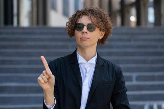 Displeased upset Caucasian young businessman reacting to unpleasant awful idea, dissatisfied with bad quality, shake finger No, dismiss idea, don't like proposal. Manager in suit outside office city.