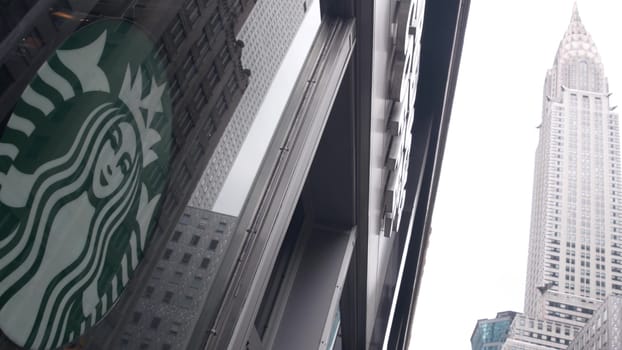 New York City, United States - 29 Aug 2023: Manhattan Midtown street, Lexington Lex avenue. Urban architecture in USA. Starbucks coffee logo, Chrysler building. High-rise skyscraper tower. NYC symbol.