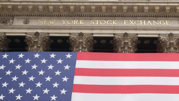 New York City, United States - 9 Sept 2023: Lower Manhattan Downtown Financial District urban architecture. Huge big American flag. Wall street Stock Exchange building, USA Stock Market trading.