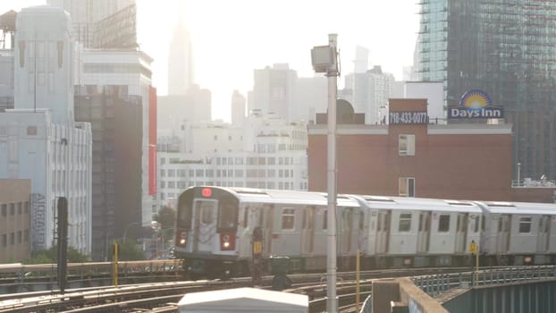 New York City, United States - 2 Sept 2023: Subway station. Metro train public transportation platform. Elevated outdoor railway, Queens passenger railroad traffic, Long Island. Empire State building.