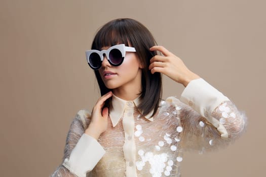 Woman, sequinned shirt, sunglasses a woman in a shimmering sequinned shirt and stylish sunglasses poses confidently for the camera, with her hand resting on her ear and her head playfully tilted to