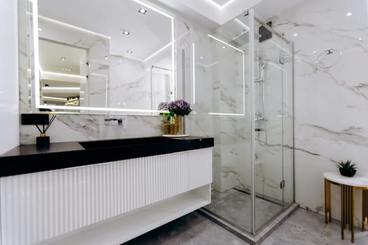This is a beautifully designed bathroom featuring a sink, a stylish mirror, and a spacious walkin shower for your comfort and convenience