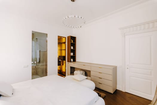 In this cozy bedroom, there are two comfortable beds, accompanied by a stylish dresser and a large mirror, creating a functional space