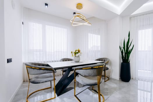 The dining room features a beautifully arranged table accompanied by several chairs, complemented by a potted plant enhancing the atmosphere