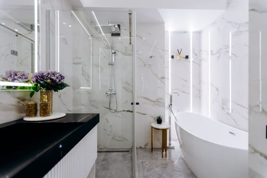 The bathroom features a cozy bathtub, a functional sink, a spacious shower, and an elegantly designed mirror that enhance the space
