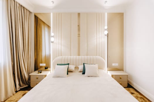 In the center of the room, there is a large and comfortable bed that serves as the focal point of the space, surrounded by furniture