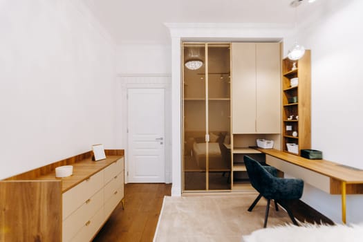 This bedroom features a desk, a comfortable chair, a dresser for storage, and elegant sliding glass doors that lead outside