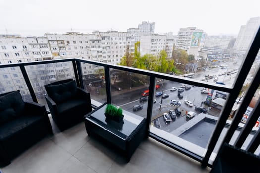 A lovely balcony that features chairs and a small table, offering an impressive view of the bustling city below, perfect for relaxation