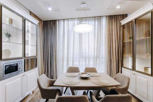 A cozy dining room features a beautifully set table and comfortable chairs arranged strategically in front of a large window
