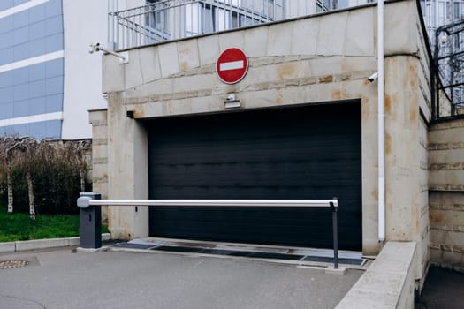 A black garage door that prominently features a no entry sign placed on it, indicating restrictions on access or usage of the area