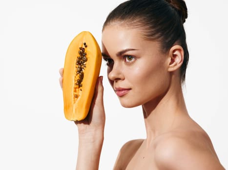 Woman Holding Papaya with Eyes Closed, Enjoying the Moment of Freshness and Natural Beauty in Tropical Surroundings