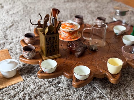 Vintage ceramic teapot and cups on linen with eucalyptus and moonstone jewelry. Tea ceremony and sensory aesthetics.