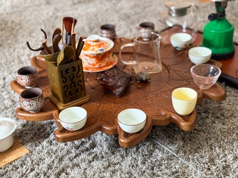 Vintage ceramic teapot and cups on linen with eucalyptus and moonstone jewelry. Tea ceremony and sensory aesthetics.