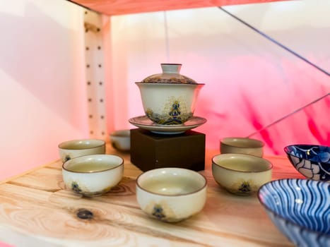 Traditional gaiwan with matching tea cups arranged on wooden surface. Harmony, ritual and elegance in Chinese tea ceremony.