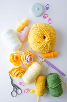 Colorful yarn and crochet tools on a white background.