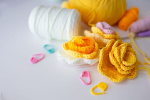 Colorful crochet flowers and yarn on a bright table.