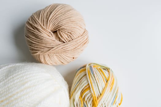 Assorted yarn balls in neutral and multicolor tones for knitting and crochet.