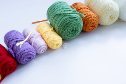 Colorful yarn balls on white background in various shades.