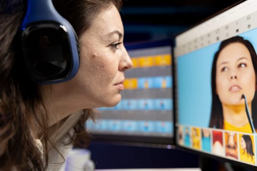 Content specialist selecting best editorial pictures for social media while listening music through headphones. Expert editing photos in advertising agency office, close up
