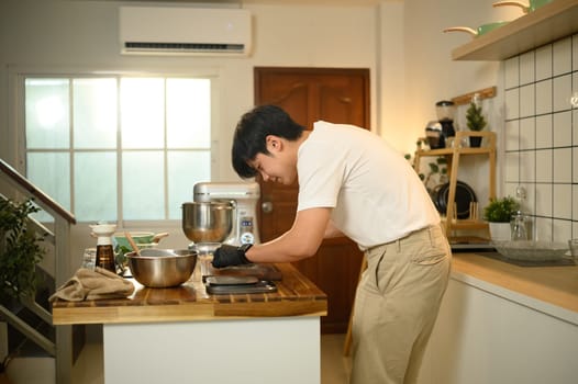 Asian man preparing ingredients for a homemade dessert recipe in a kitchen.