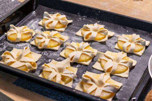 Shot of the a pineapple wedges wrapped in puff pastry on the baking tray