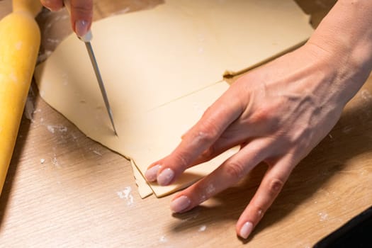 A woman cuts puff pastry