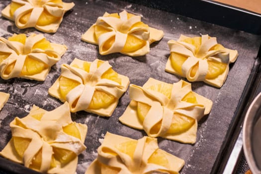 Shot of the a pineapple wedges wrapped in puff pastry on the baking tray