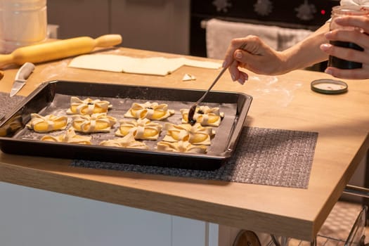A woman place cherry on the top of the puff pastry with pineapple wedges wrapped.