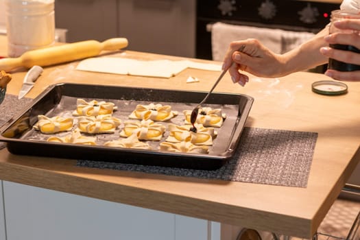 A woman place cherry on the top of the puff pastry with pineapple wedges wrapped.
