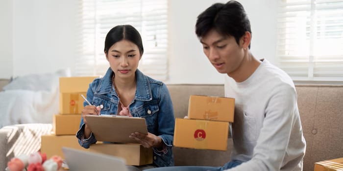 In a bright home office, this couple is dedicated to streamlining their e-commerce processes, demonstrating effective teamwork in a modern business environment.