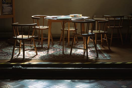 Windsor, UK - Apr 03, 2025 - Sunbeam rays filtered through in to the Wooden tables and chairs inside of Parish Church of St John the Baptist in the afternoon. use it as your Wallpaper, Poster and Space for text, Selective focus.
