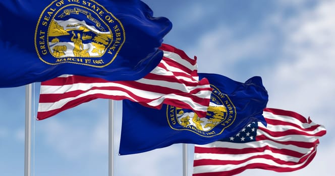 High-resolution 3D render of the Nebraska state flag and US national flag fluttering in the sky. Symbols of unity, patriotism, and independence in the American Midwest