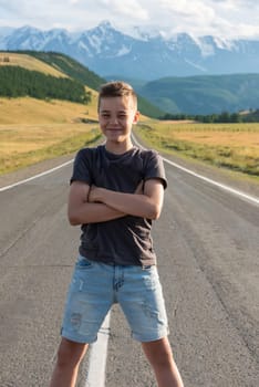 Smiling teen boy on the road in Altai Mountains. Travel concept