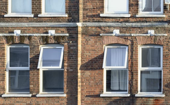 London, UK - Apr 06, 2025 - The sunshine lights through the glass window frame exterior of old house. Glass window and brick wall in London, use it as your Wallpaper, Poster and Copy space, Selective focus.