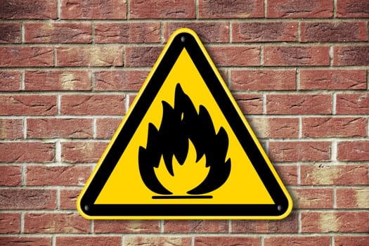 A fire hazard warning sign on a brick wall background