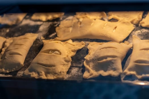 Puff pastries with cottage cheese filling baking in the oven