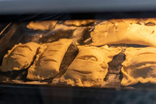 Puff pastries with cottage cheese filling baking in the oven