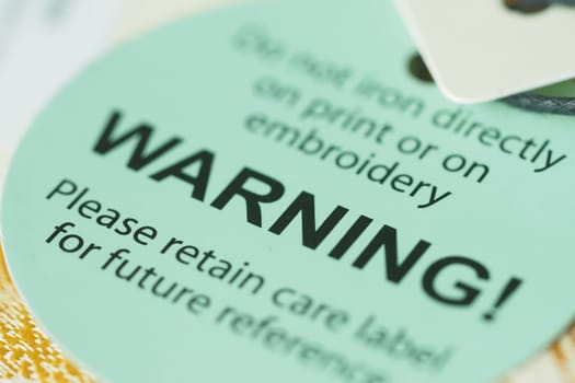 A close-up view of a warning label advising on garment care.