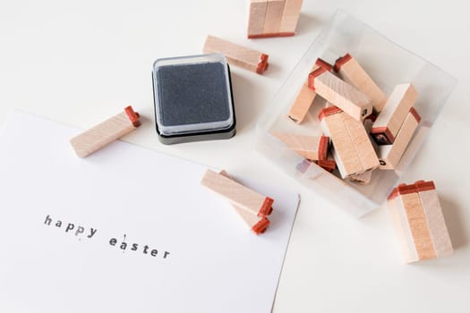 Happy Easter letter stamping with wooden blocks and ink pad.