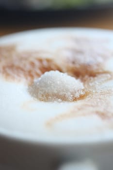 sugar pouring on a coffee .
