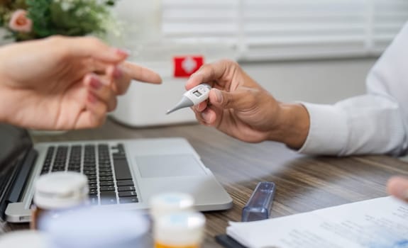 The healthcare professional engages the patient in monitoring health status, illustrating the importance of temperature checks in their medical assessment.