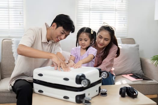 A playful family moment as a father and daughter join forces to pack a suitcase, creating a fun atmosphere filled with happiness and warmth.