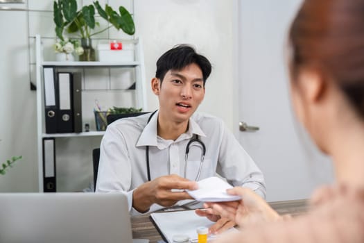 A healthcare provider gives a patient a prescription after discussing medication options during a home visit.