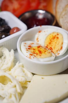 Breakfast platter with boiled eggs, cheese, and fresh veggies.