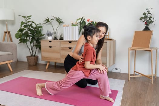 A mother guides her daughter during stretching exercises, promoting a healthy lifestyle while building a strong, supportive relationship.