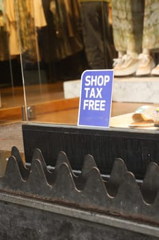 A tax free shopping sign displayed in a store window, inviting customers.