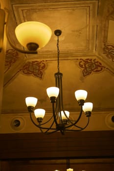 Warm light emanates from a classic chandelier in a historic setting.