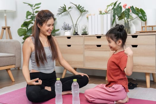 Amidst a workout, a mother engages her daughter in a moment of mindfulness, highlighting both strength and emotional connection.